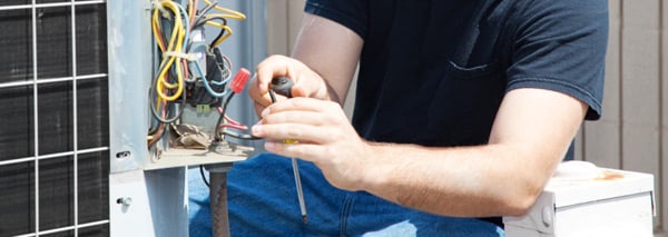 Close up of an HVAC technician repairing an air conditioner